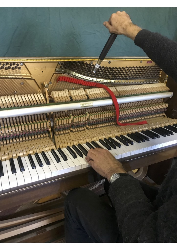 Upright piano being professionally tuned