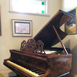 Restored 19th century Bluthner grand piano in a sunlit room